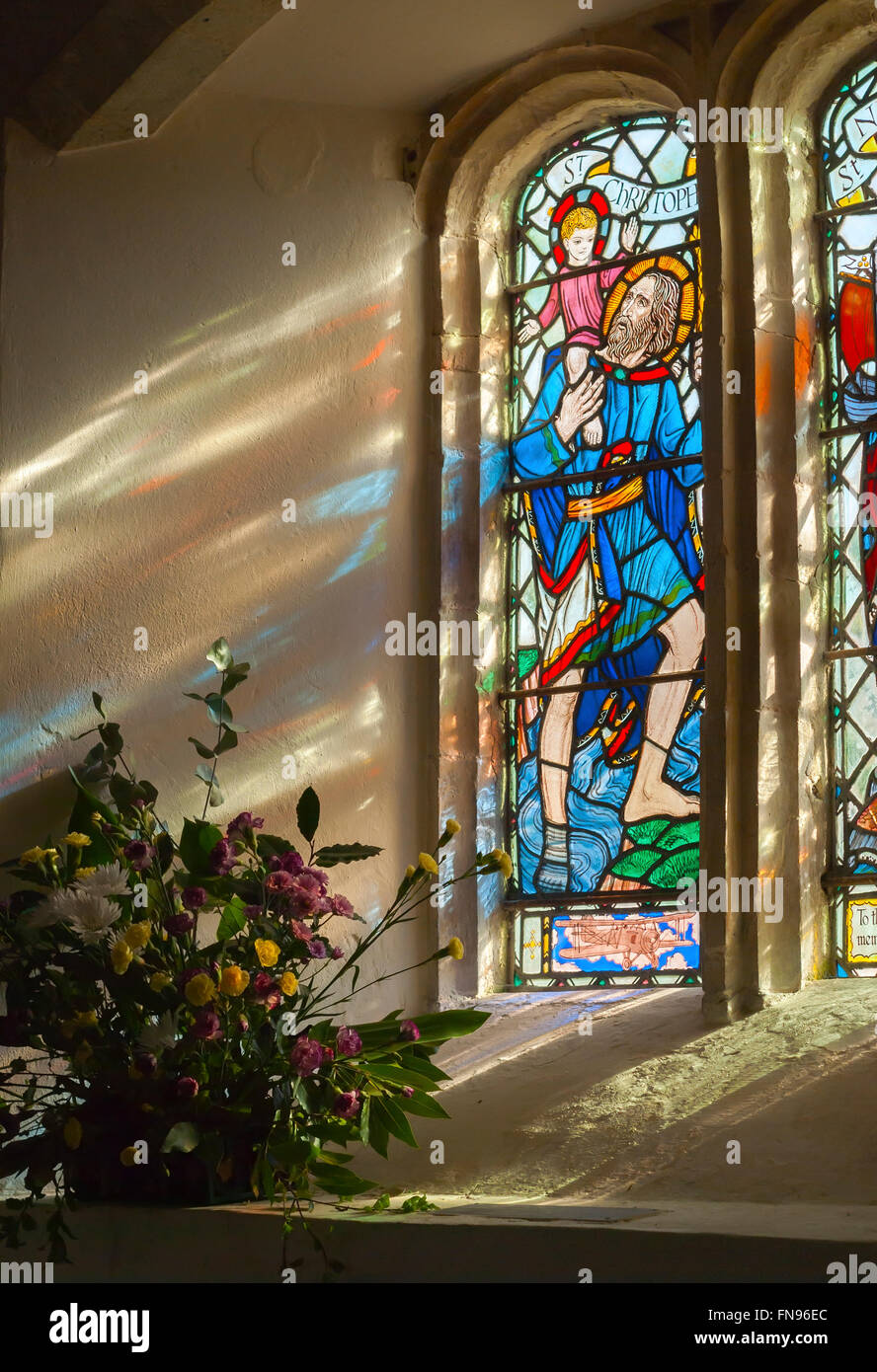 Stained glass panel and transmitted light reflections from St Nicholas Church West Itchenor West Sussex UK Stock Photo
