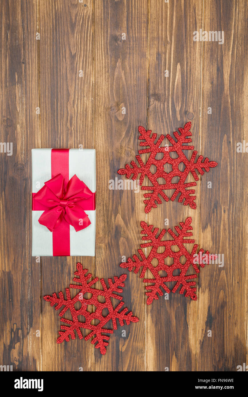 white Gift red silk wrap  for holiday event with Snowflake on wooden background Stock Photo