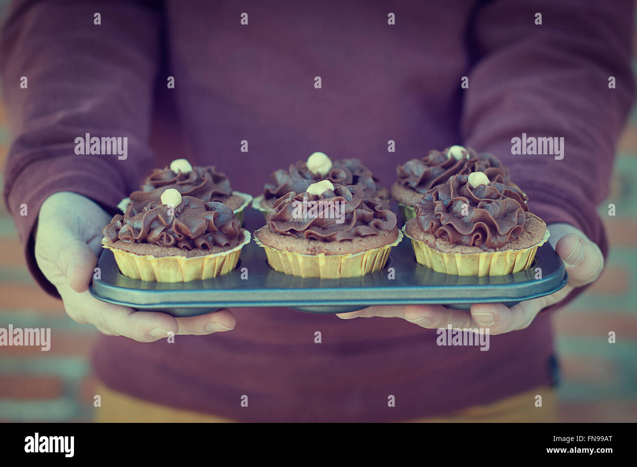 Man holding tray of chocolate cupcakes Stock Photo