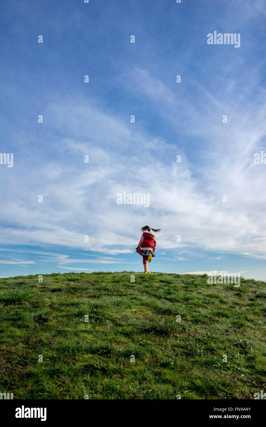 Girl on a hill spinning around Stock Photo