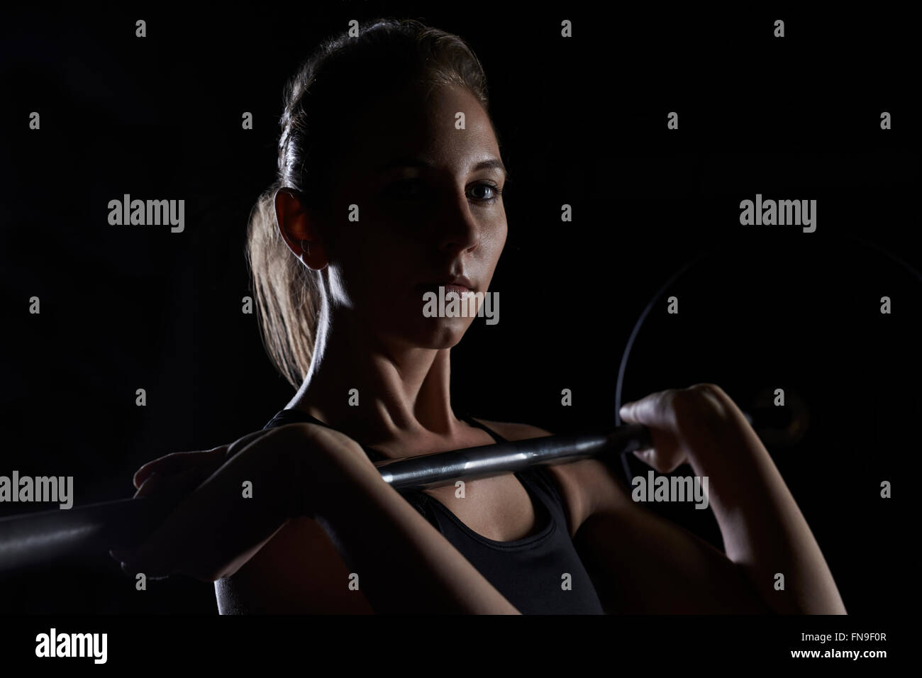 Woman lifting barbell in gym Stock Photo