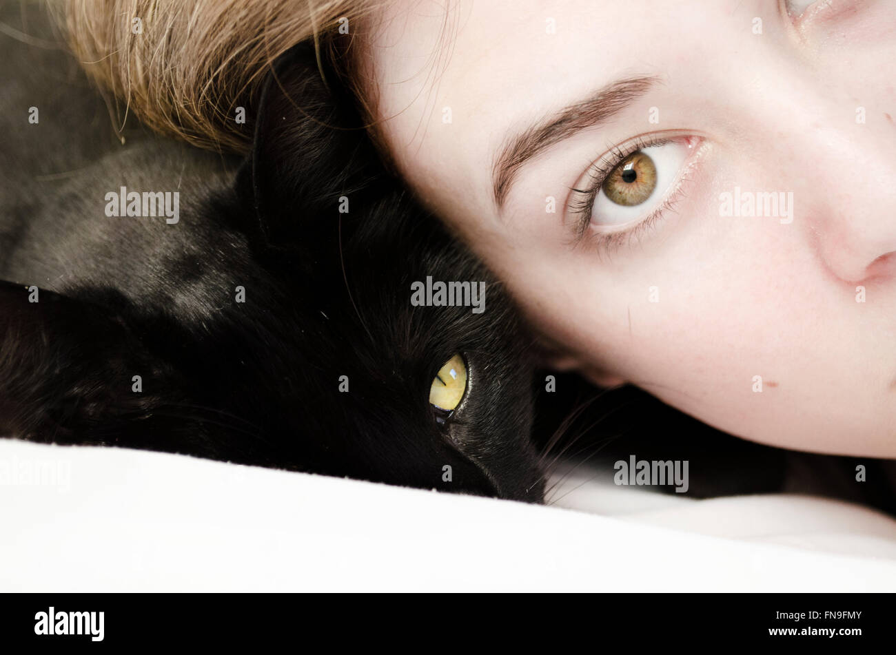 Portrait of a woman and cat lying next to each other Stock Photo