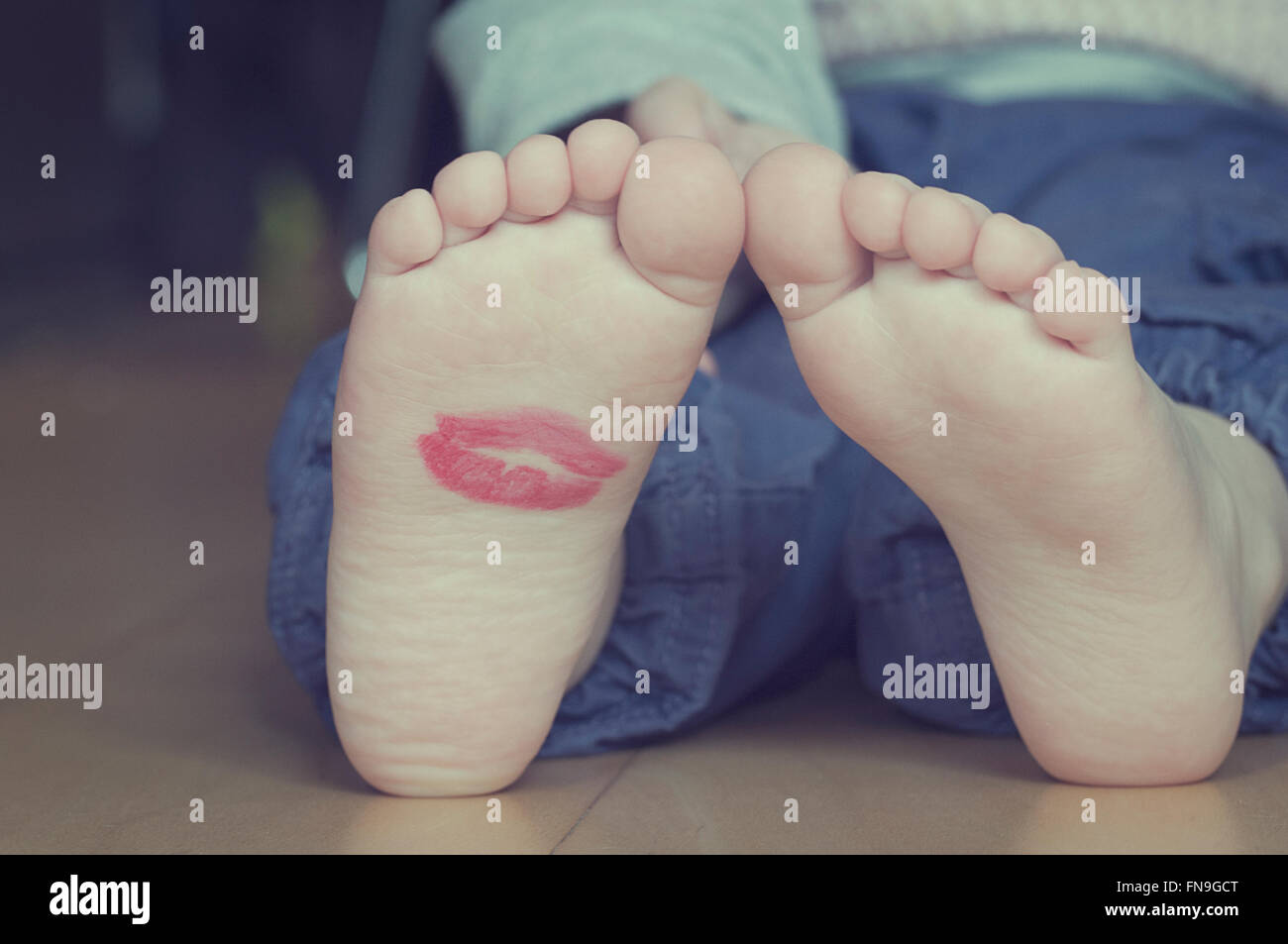 Lipstick kiss on toddler's foot Stock Photo