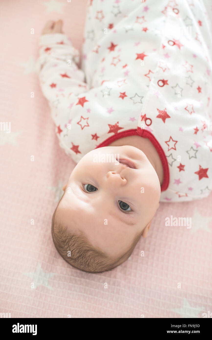 Baby girl lying in a cot Stock Photo