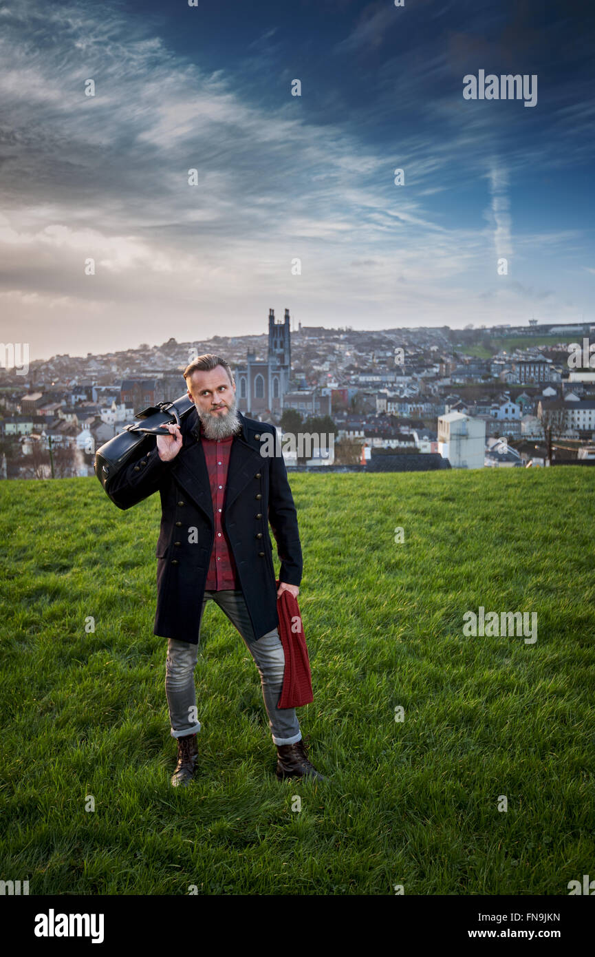 Hipster man with bag in park, Cork, Ireland Stock Photo