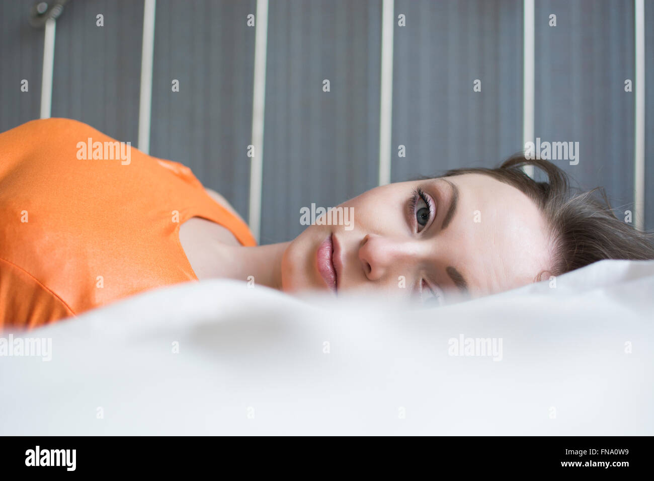 Young woman in bed alone Stock Photo