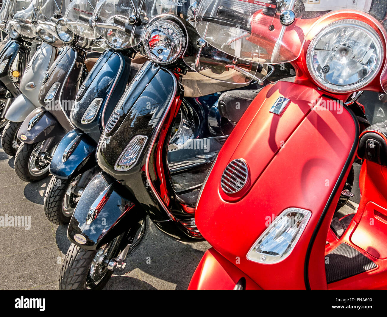 Row of new Italian vespa scooters for sale in front of a shop in the Netherlands Stock Photo