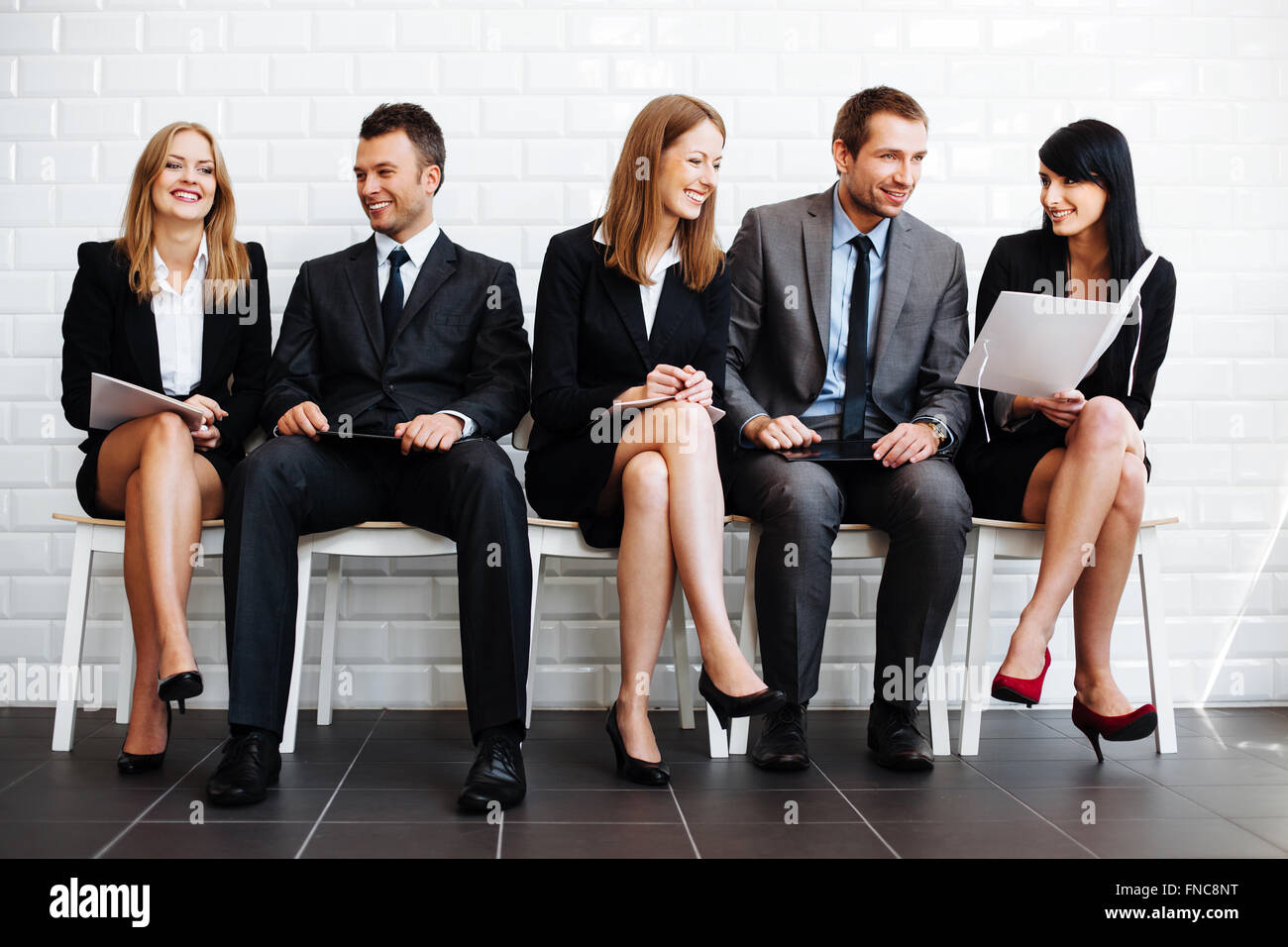 Group of happy business people sitting in waiting room Stock Photo - Alamy