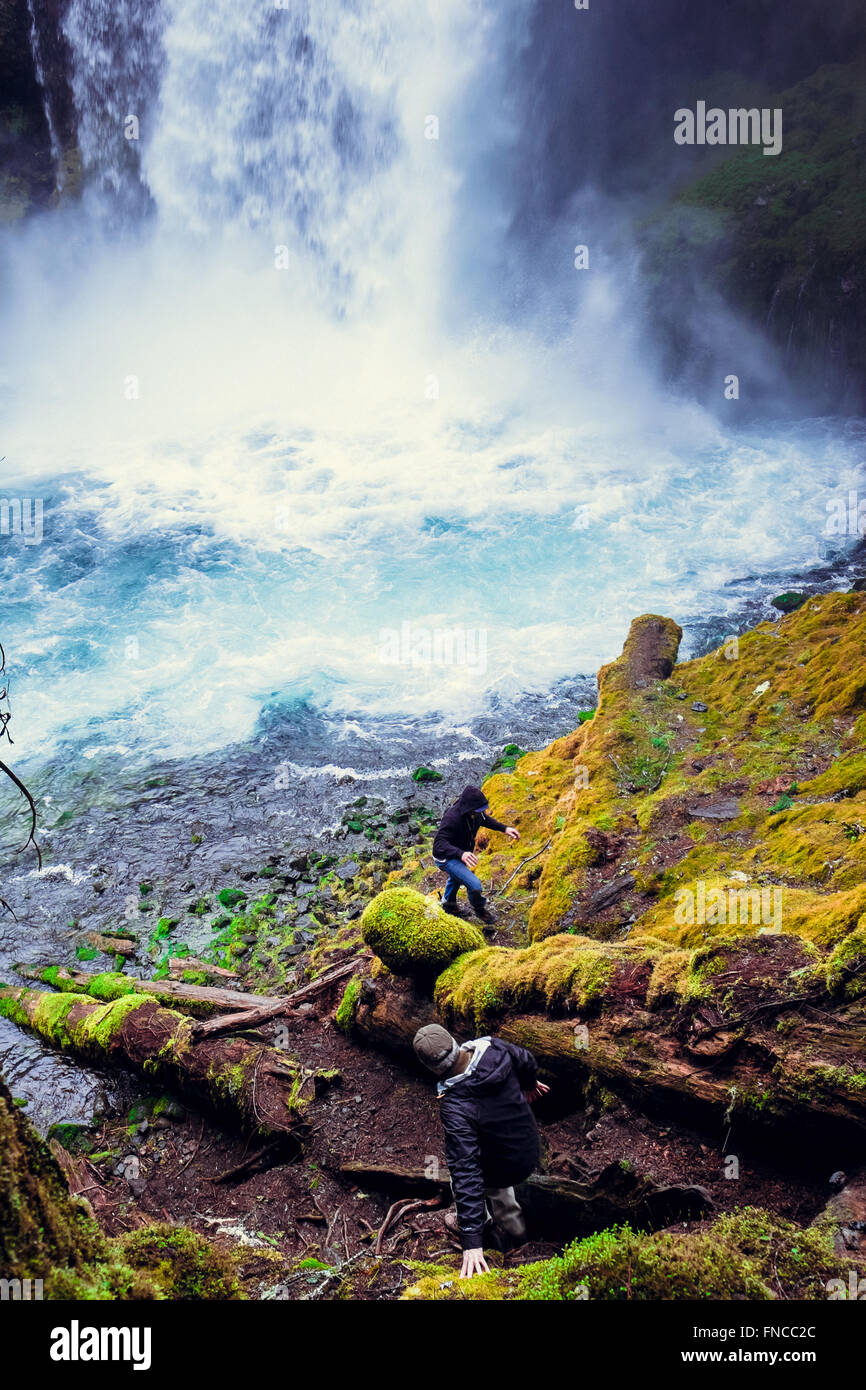 Two men explore Koosah Falls in Oregon along the historic McKenzie River. Stock Photo