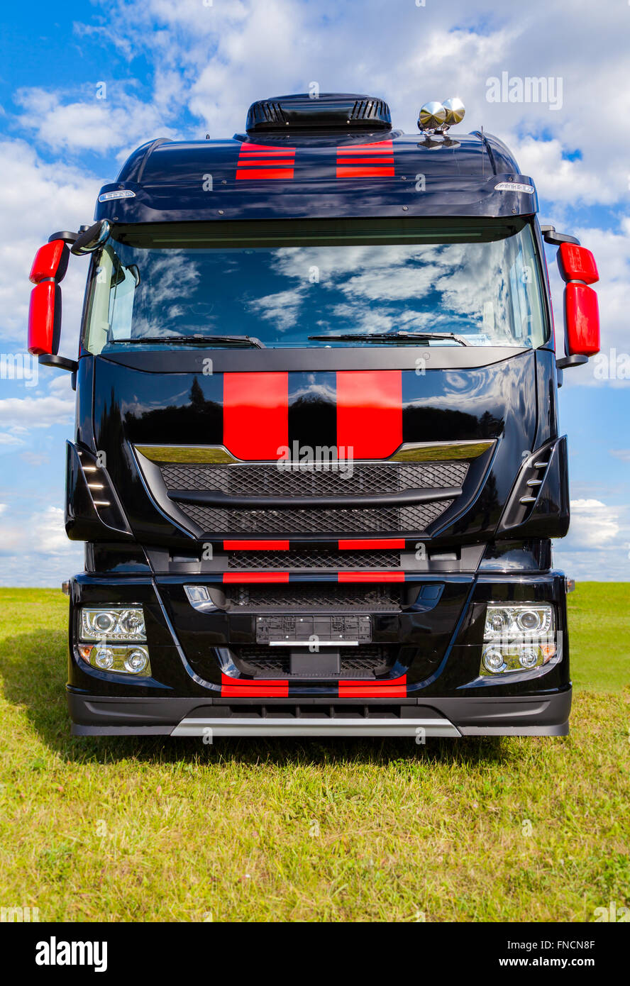 red striped big rig on grass Stock Photo