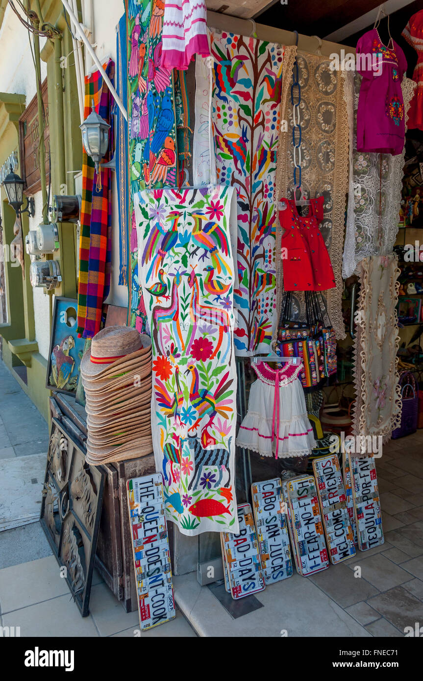 Colorful Mexican textiles, hats, + license plate cut ups outside tourist shop in Old Town San Jose del Cabo, Los Cabos, Mexico. Stock Photo