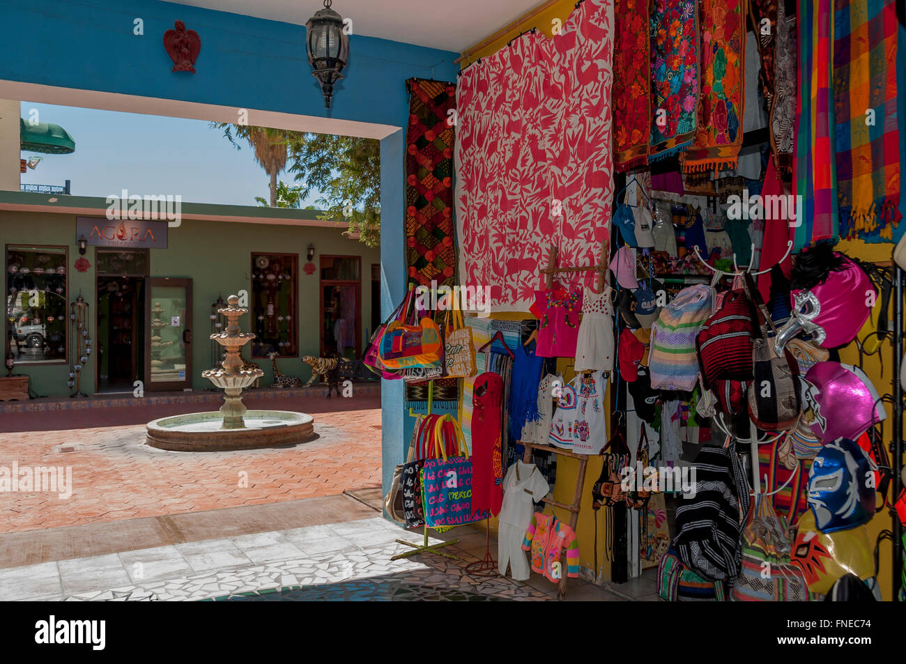 Colorful Mexican textiles + wrestling masks decorate a gallery of shops with courtyard in Old Town San Jose del Cabo, Los Cabos. Stock Photo