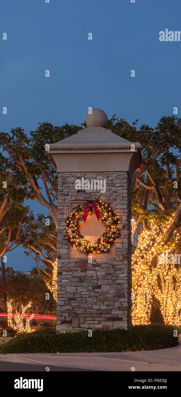 Christmas holiday wreath with white lights on a brick pillar Stock