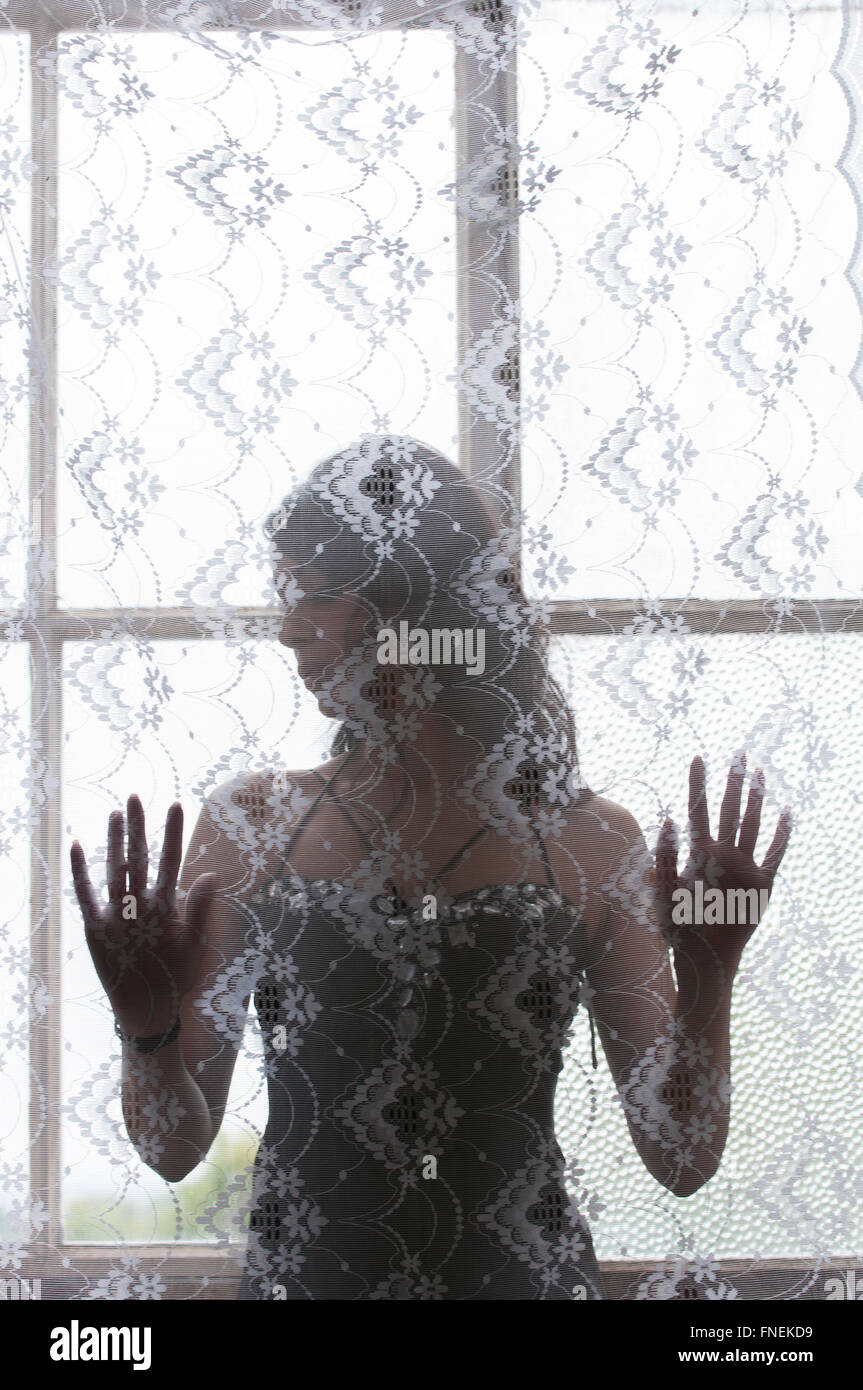 Unhappy Indian woman by the window Stock Photo