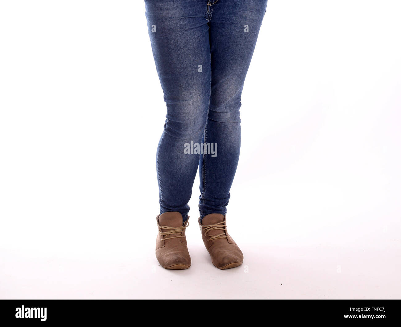 Legs of a young woman in boots and tight jeans Stock Photo