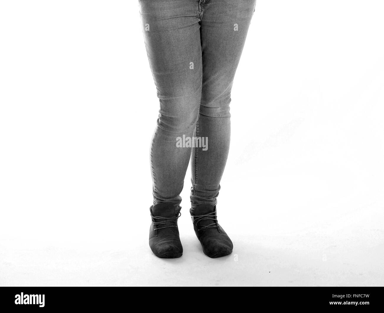 Legs of a young woman in boots and tight jeans Stock Photo