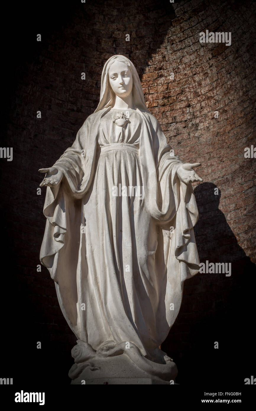 Statues of Holy Women in Roman Catholic Church on wall background. Stock Photo