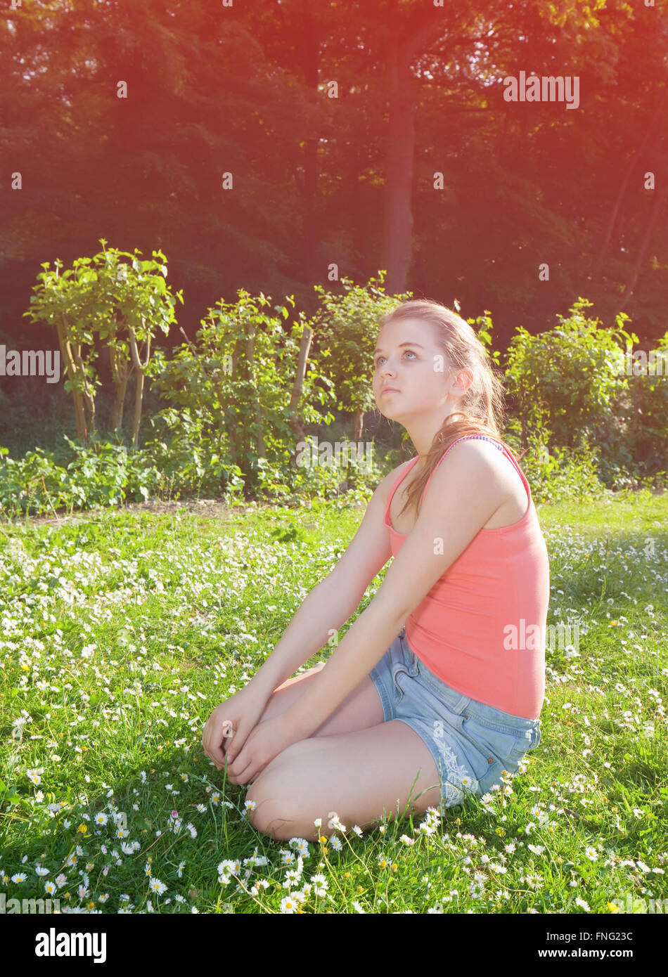 young girl sitting on green grass Stock Photo