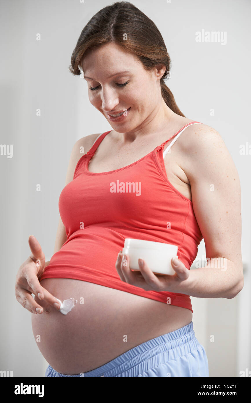 Pregnant Woman Moisturizing Belly Stock Photo