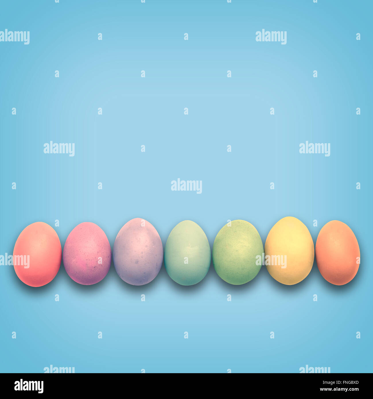 Pastel Easter eggs aligned, blue background Stock Photo