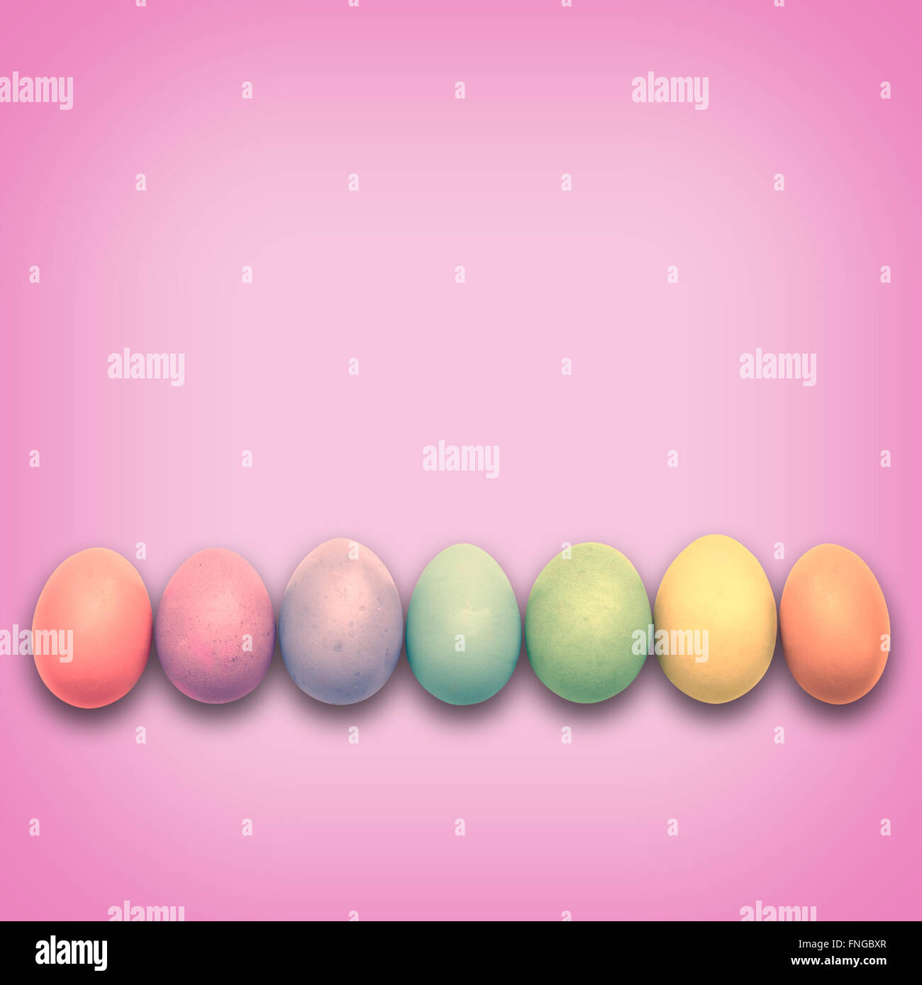 Pastel Easter eggs aligned, pink background Stock Photo