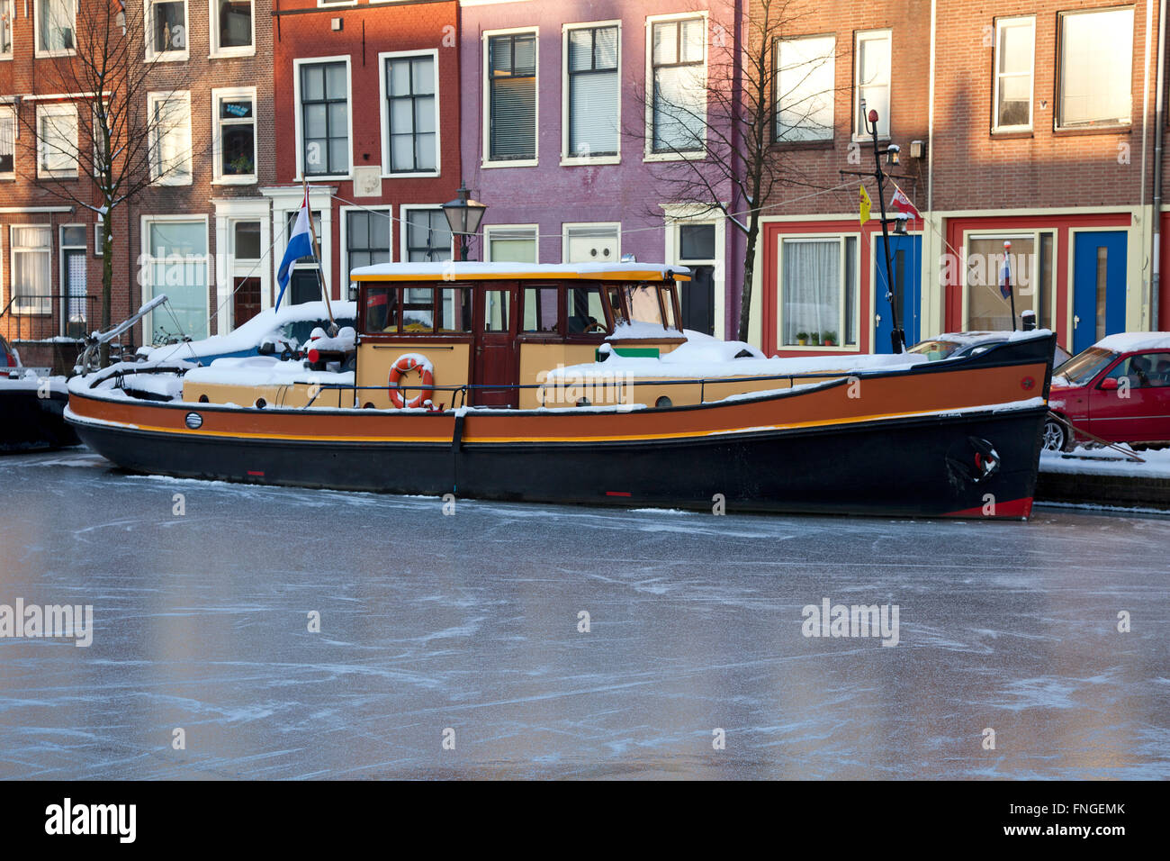 Tugboat in a frozen canal in winter in Holland Stock Photo