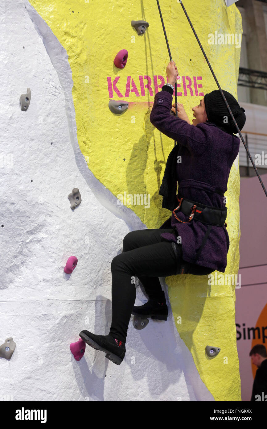 Girl on a climbing wall at the booth of Deutsche Telekom at CeBIT digital technology trade fair 2016 in Hannover, Germany. The word 'career' (or 'ladder of Success') is written on the wall. Stock Photo