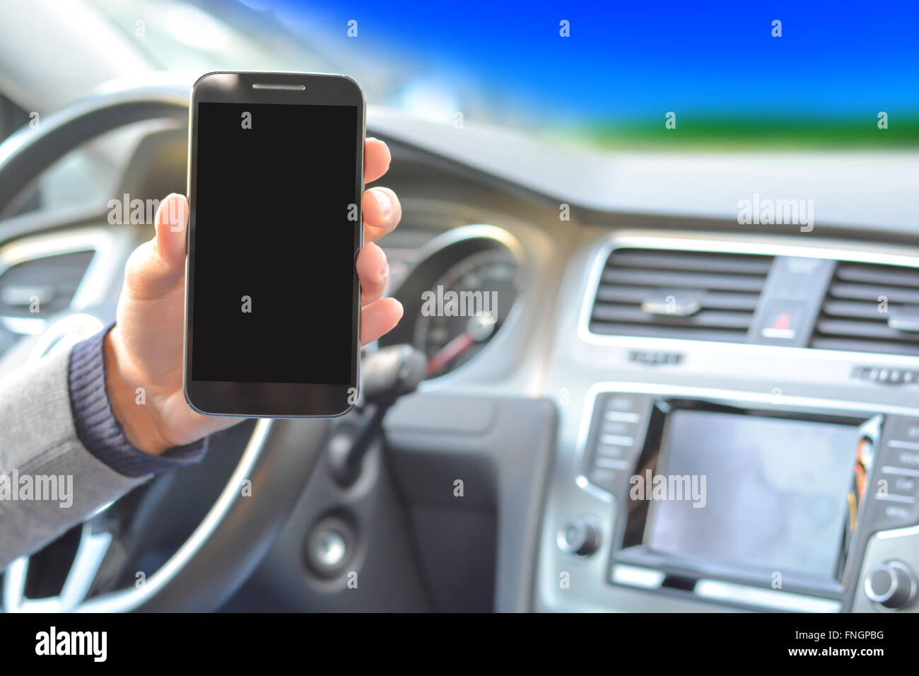 Smartphone hold by man inside a car while driving Stock Photo