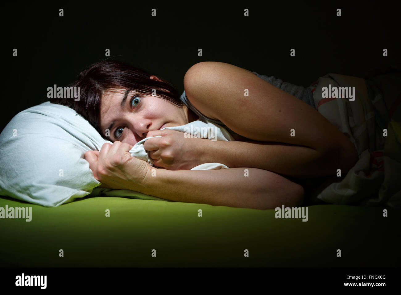 Young woman in bed with eyes opened suffering insomnia. Sleeping concept and nightmare issues Stock Photo