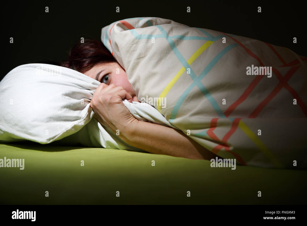 Young woman in bed with eyes opened suffering insomnia. Sleeping concept and nightmare issues
