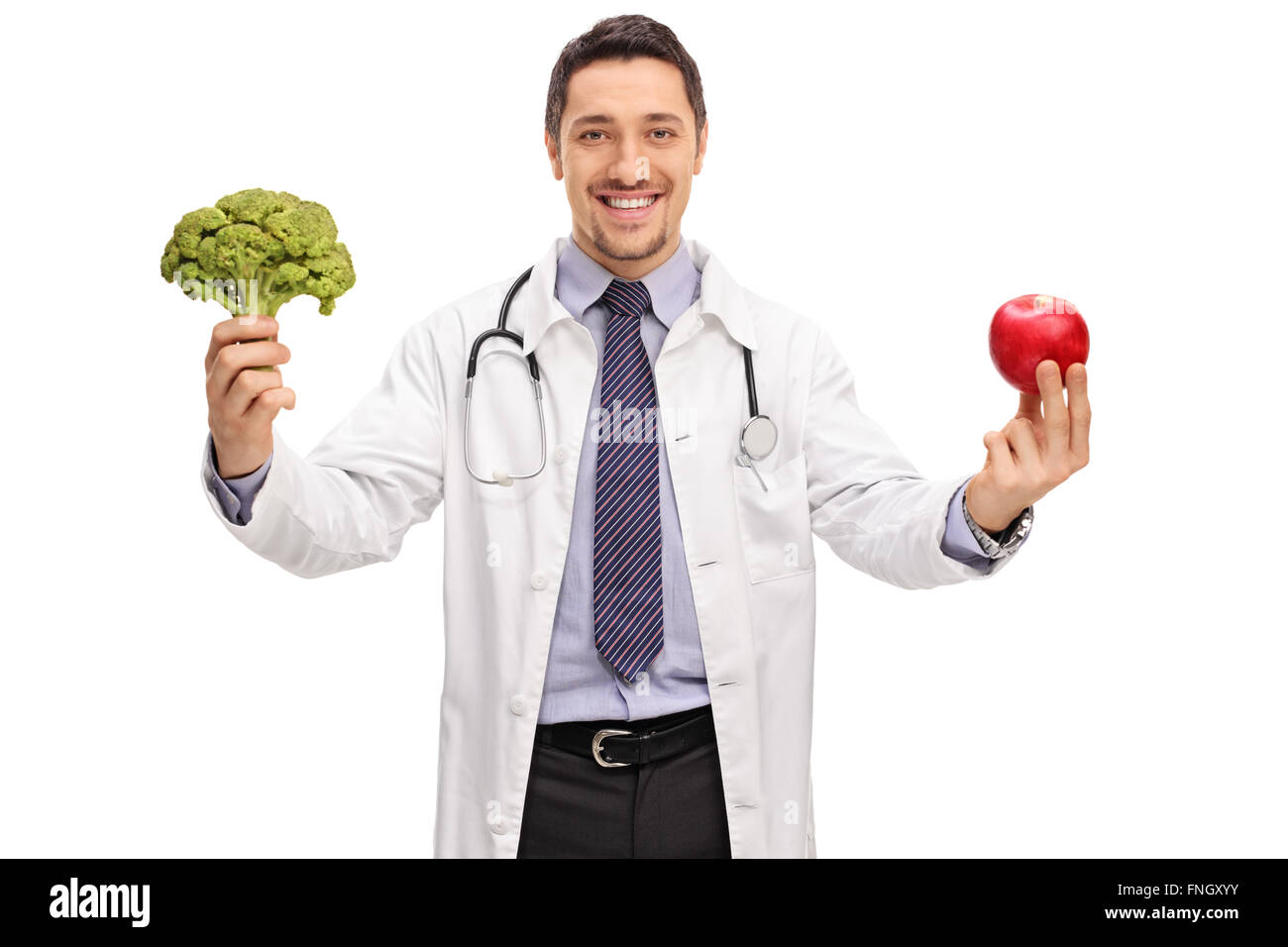 Young cheerful nutritionist holding a piece of broccoli and an apple isolated on white background Stock Photo