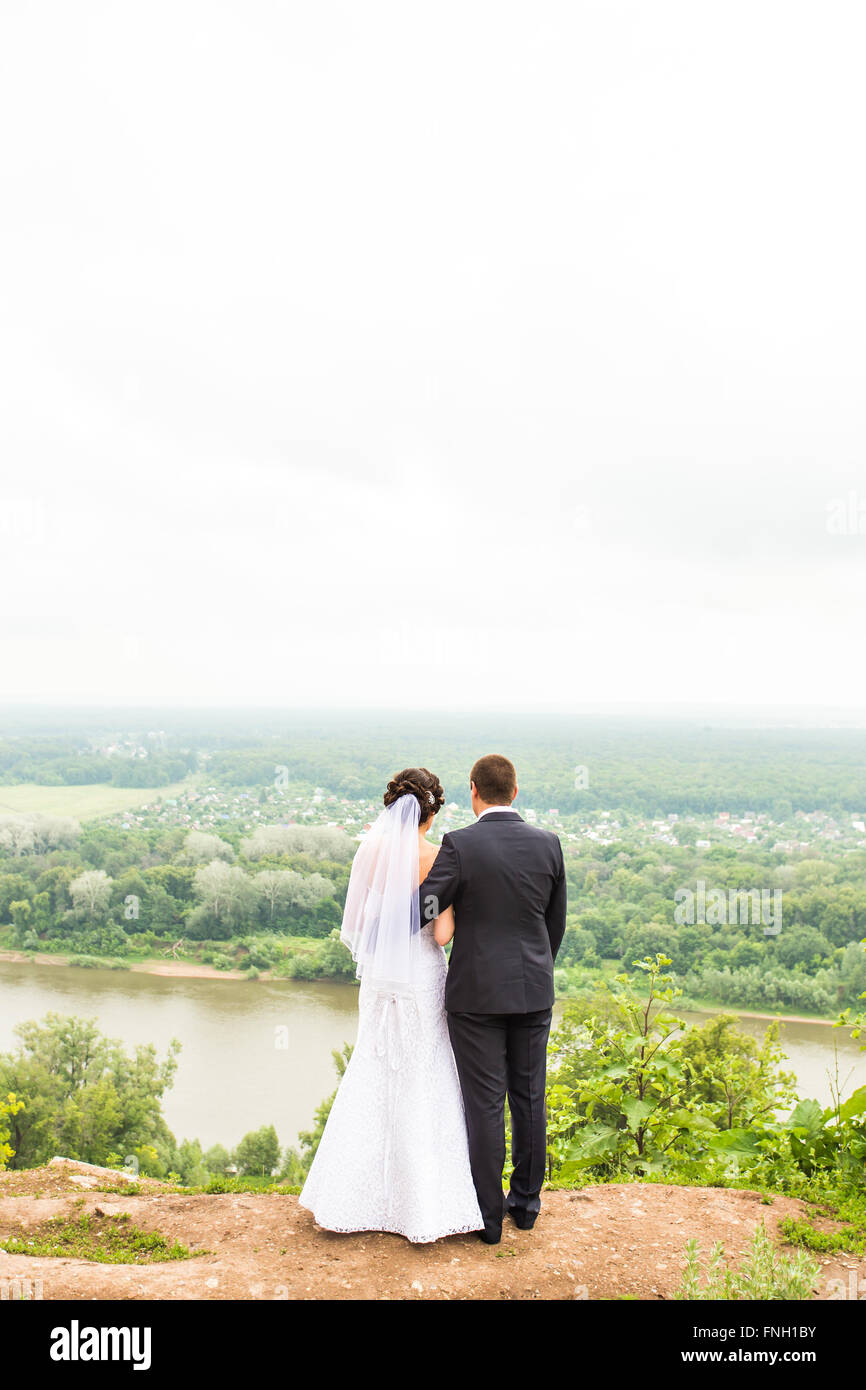 Back view of holding hands bride and groom outdoors Stock Photo - Alamy