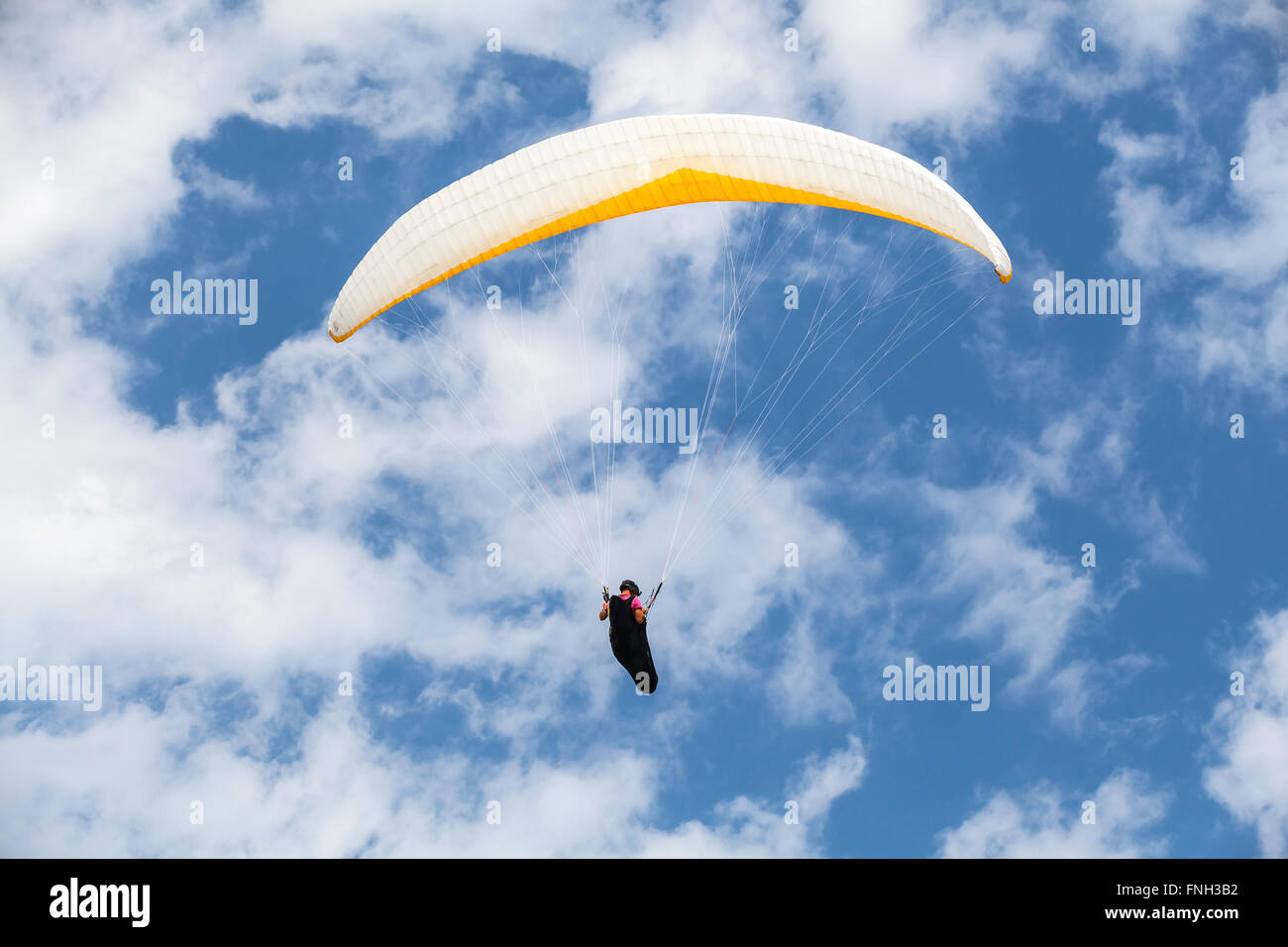 Amateur paraglider in blue sky with clouds Stock Photo