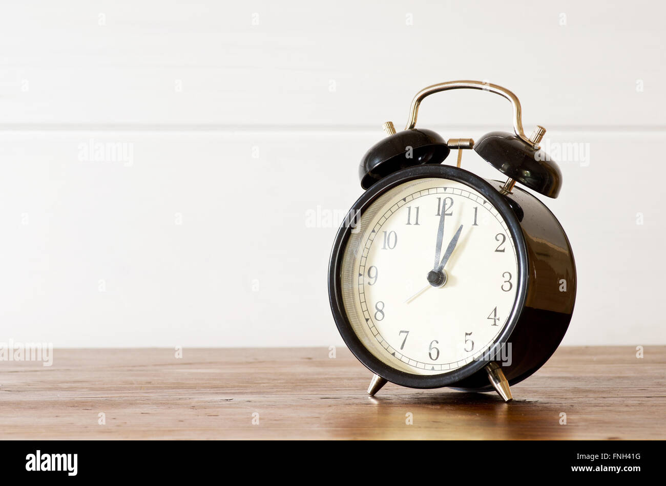 Retro alarm clock and white wooden wall background Stock Photo - Alamy
