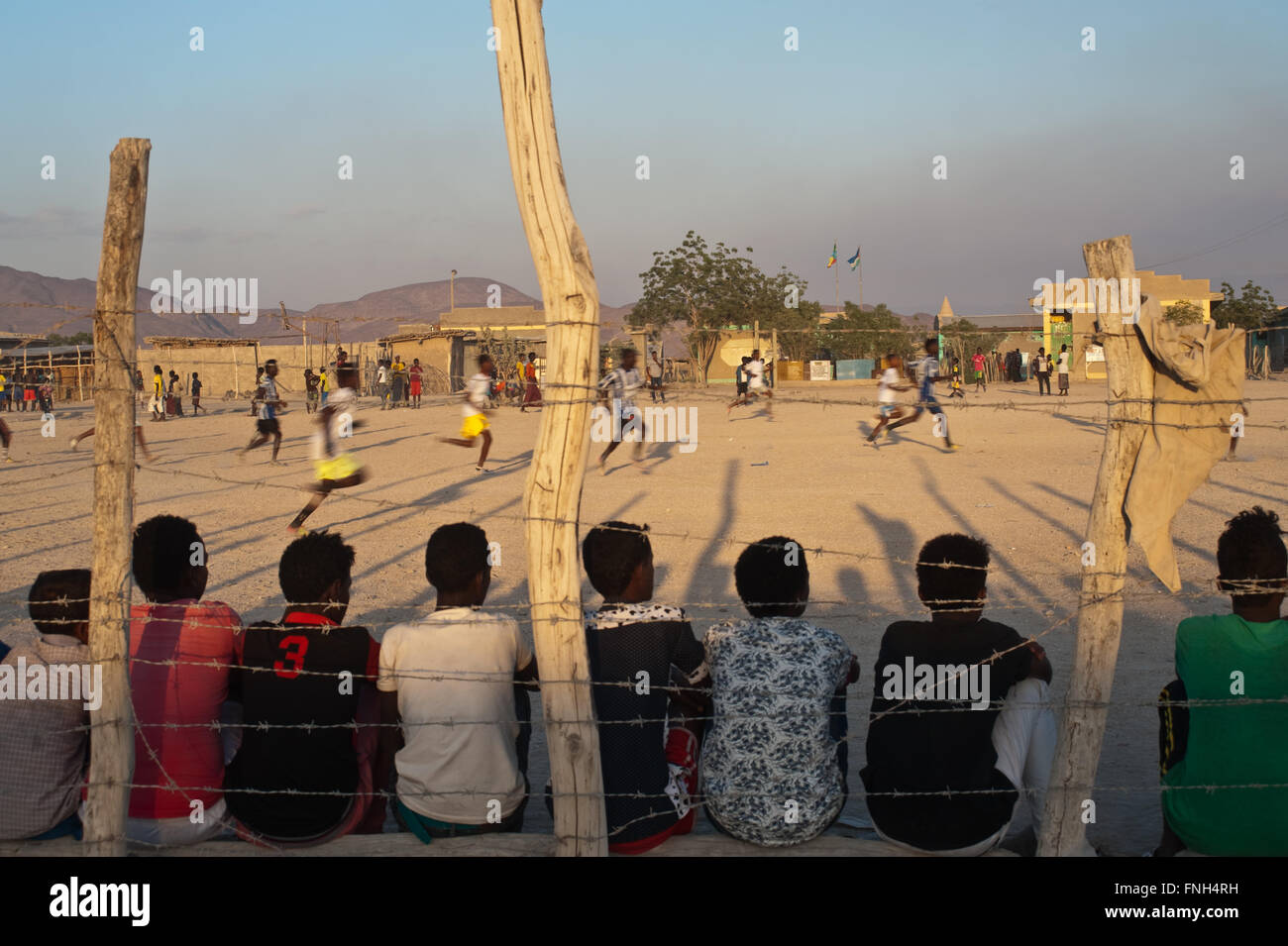 Boys are playing football in their school compound. In the foreground, local boys are watching the game ( Ethiopia) Stock Photo