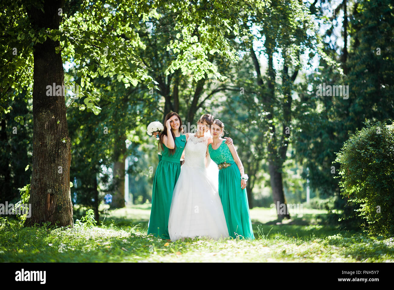 Gorgeous bride with bridesmaids posed on sunshine park Stock Photo