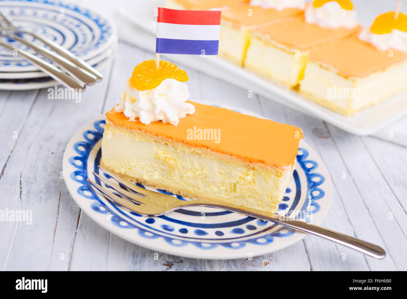 An orange tompouce, traditional Dutch pastry, on a white background. The orange icing on the tompouce is typical for King's Day Stock Photo