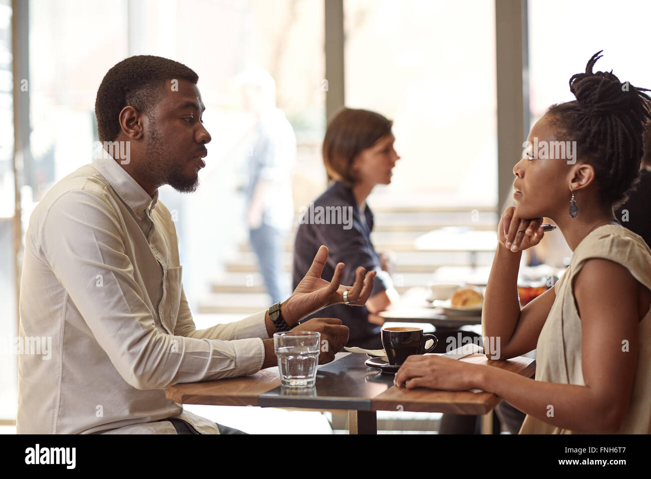 African entrepreneur explaining his idea to a businesswoman in c Stock Photo