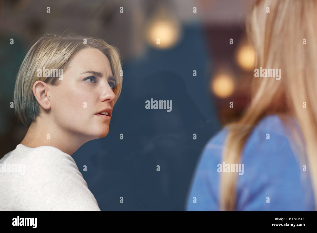 Woman looking concerned while listening carefully to her friend Stock Photo