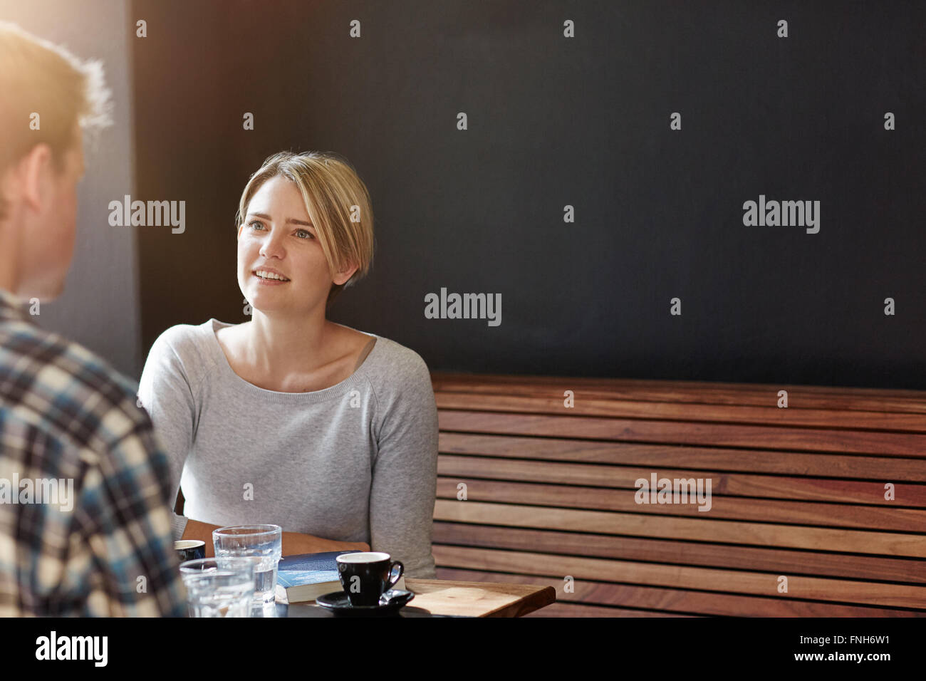 Young woman having coffee with man against dark grey background Stock Photo