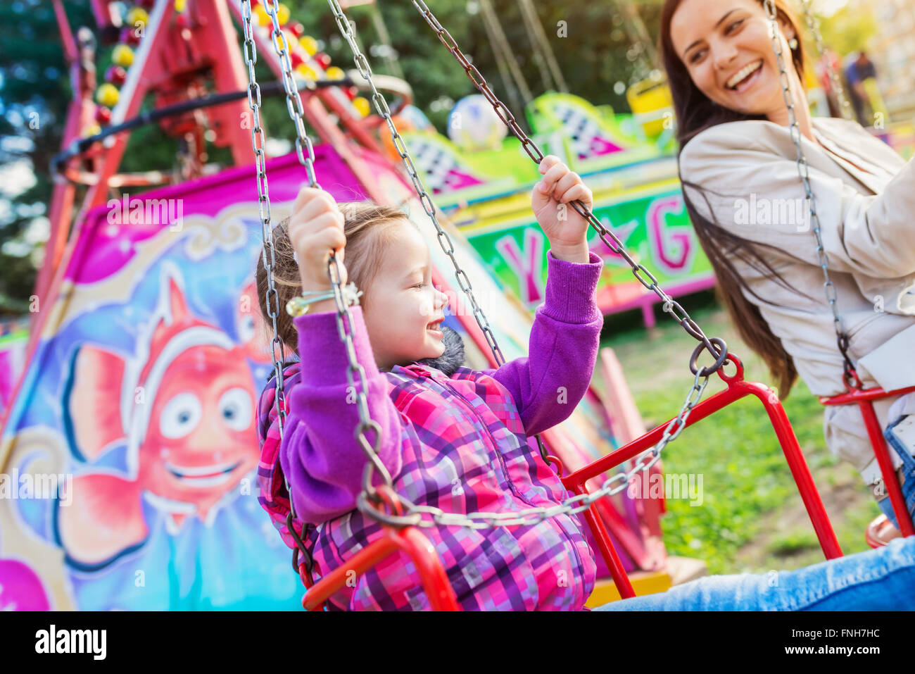 Mother and daughter at fun fair, chain swing ride Stock Photo