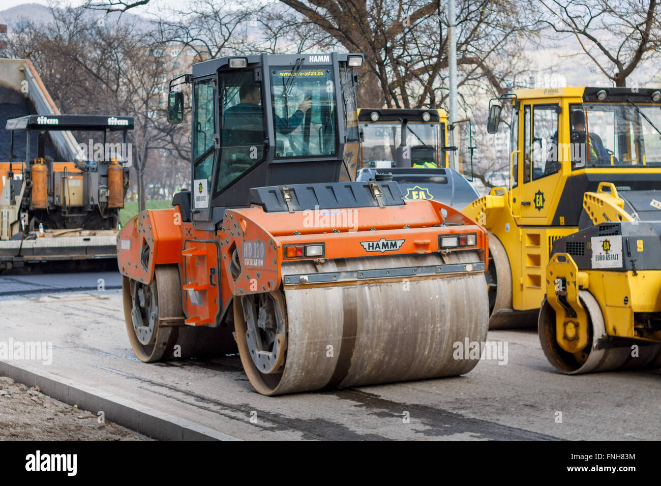 Road construction vehicles asphalting, paver and roller Stock Photo