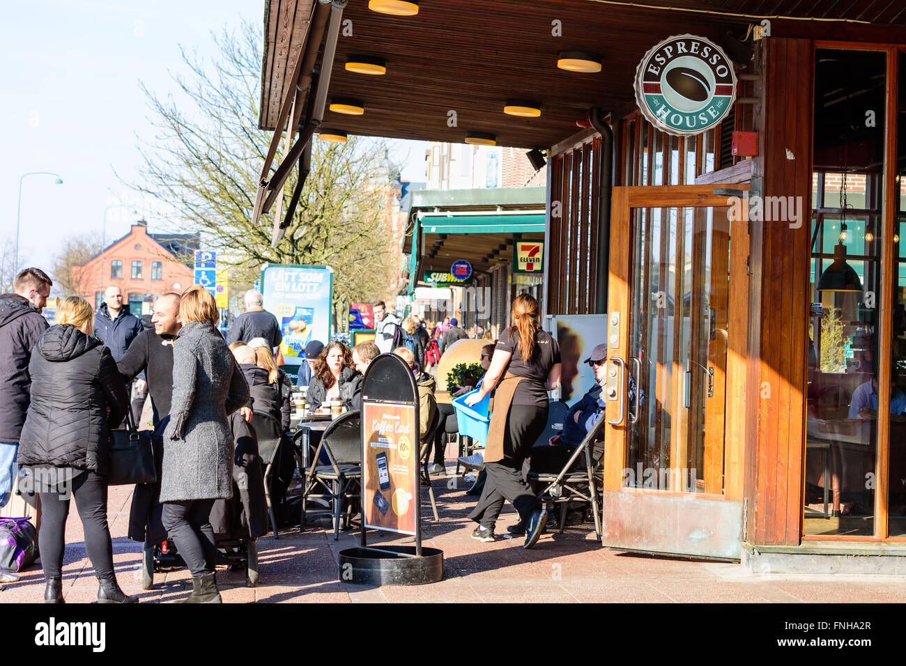 Lund, Sweden - March 12, 2016: People having coffee and enjoying each others company. Waitress coming out of Espresso House to f Stock Photo