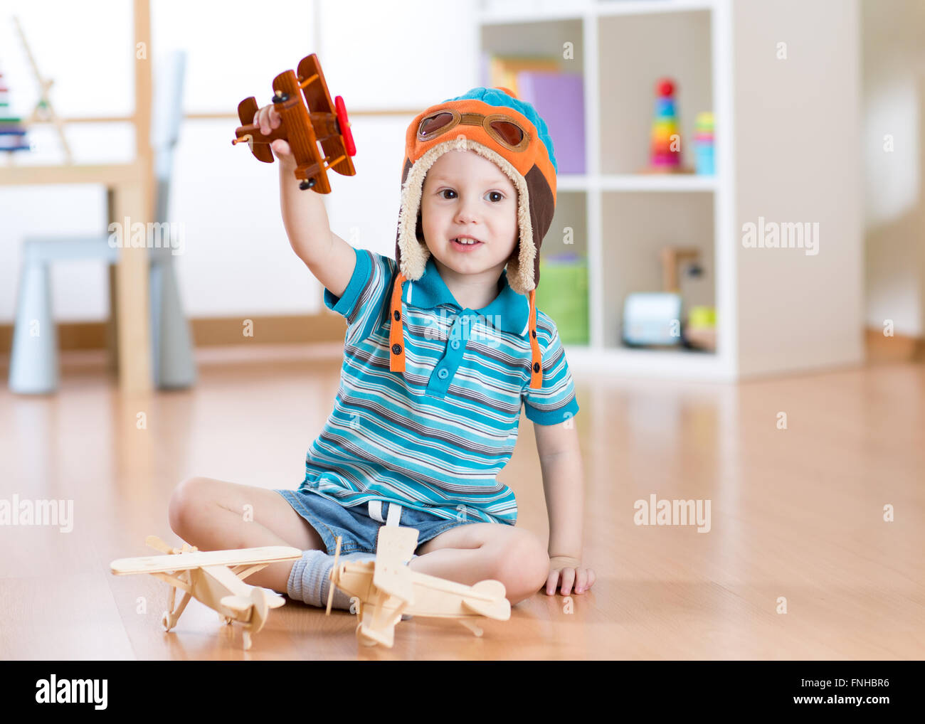 Happy child playing with toy airplane at home Stock Photo