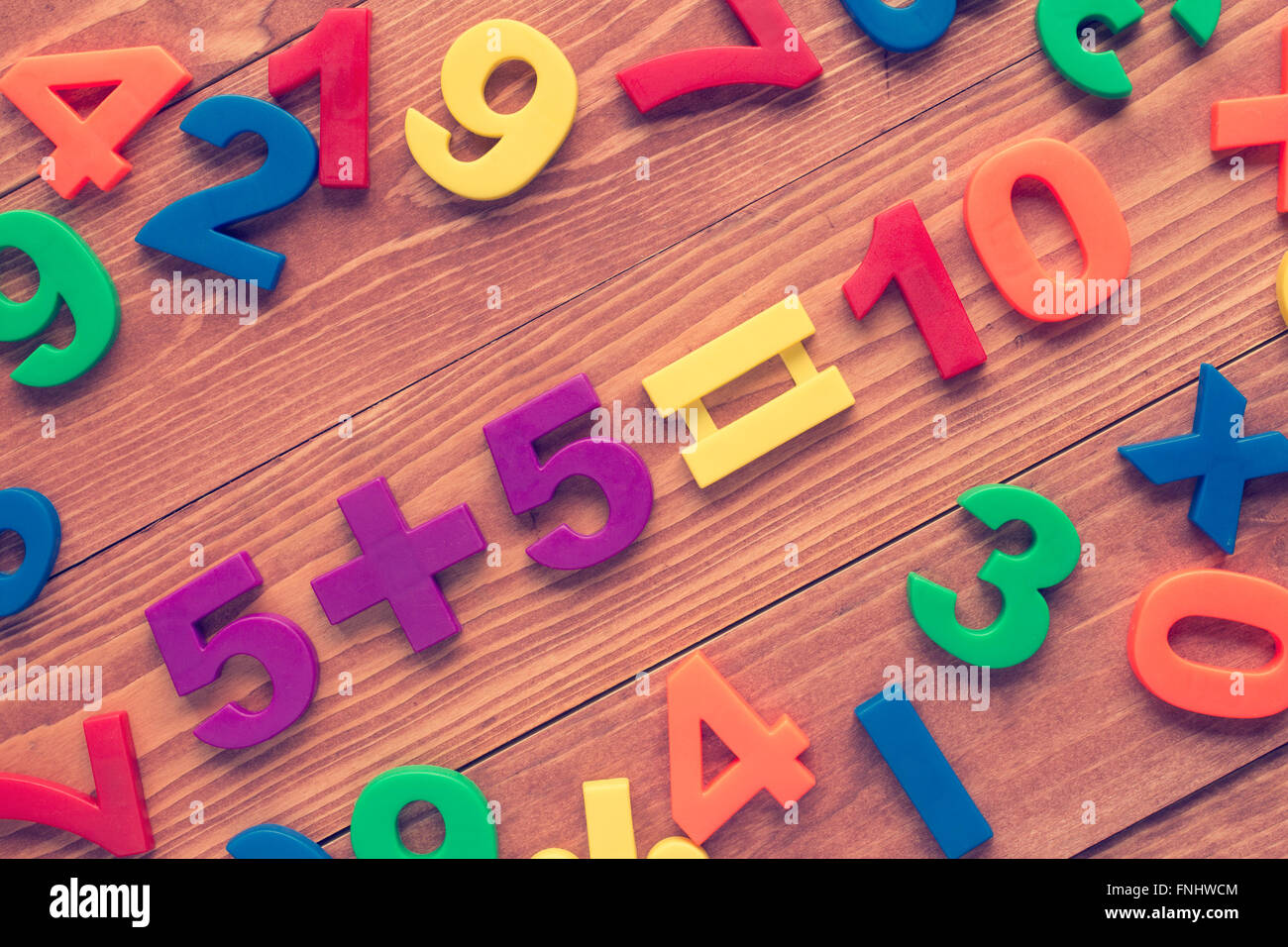 Five add five, simple math addition on wooden background. Cross ...