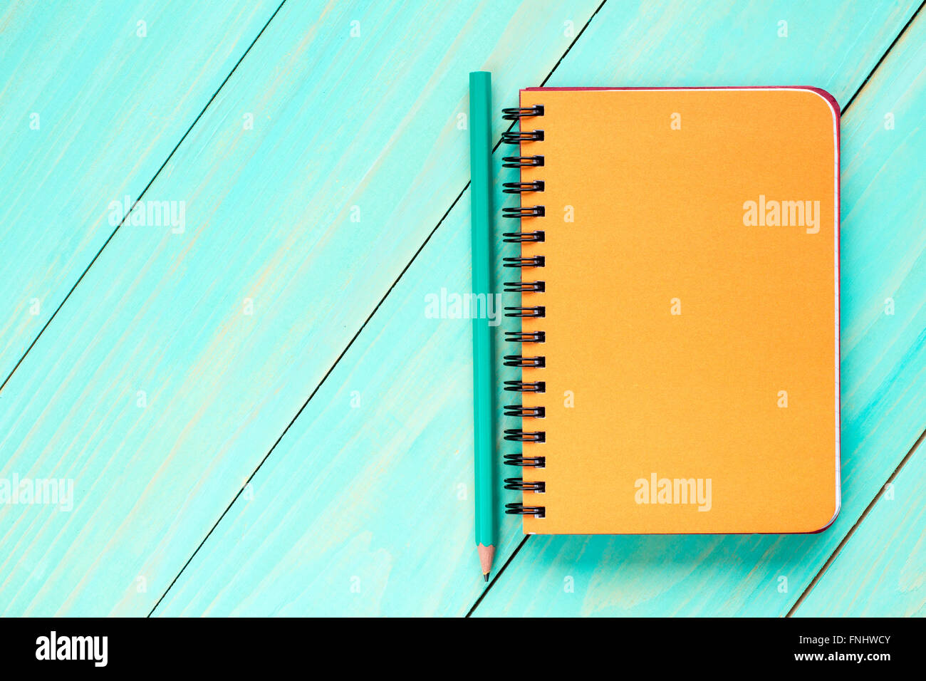 Blank spiral notebook with pencil on the wooden background.Top view ...