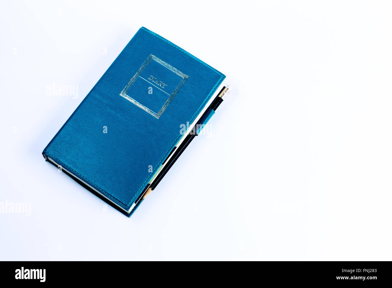 Blue green leather diary notebook with pencil isolated on white background Stock Photo