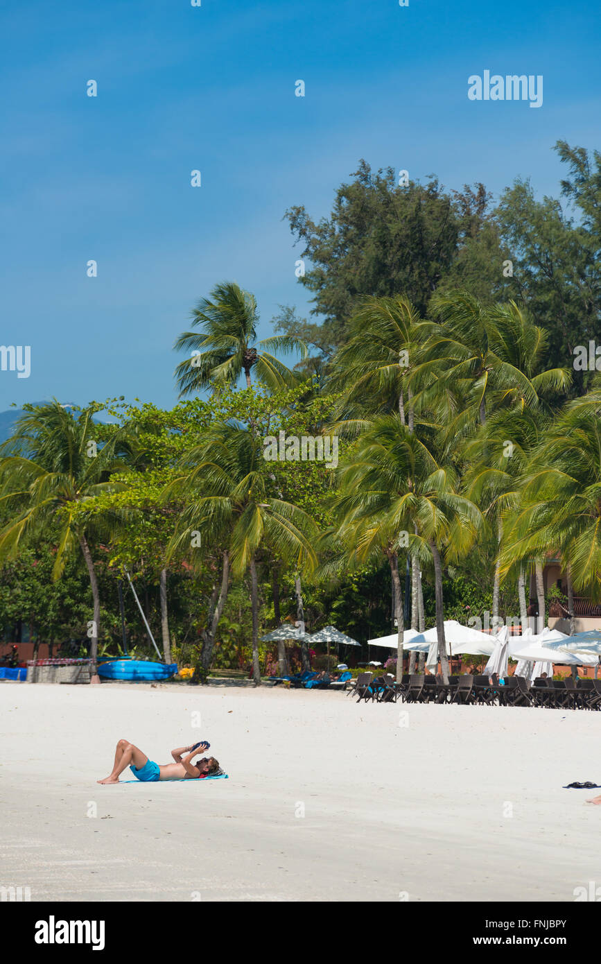 Man reading book on Cenang Beach, Langkawi, Malaysia Stock Photo