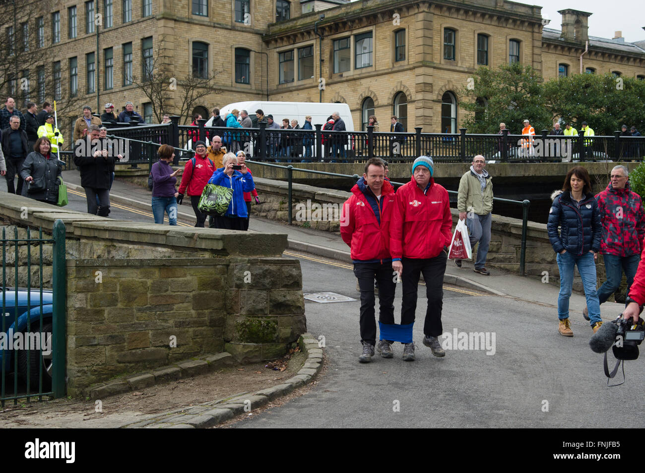 Saltaire, UK. 15th March, 2016. Look North television presenter Harry Gration (right) and Look North weather man Paul Hudson (left) in Saltaire on day six of their charity three legged walk around Yorkshire for Sport Relief. Credit:  Ian Lamond/Alamy Live News Stock Photo
