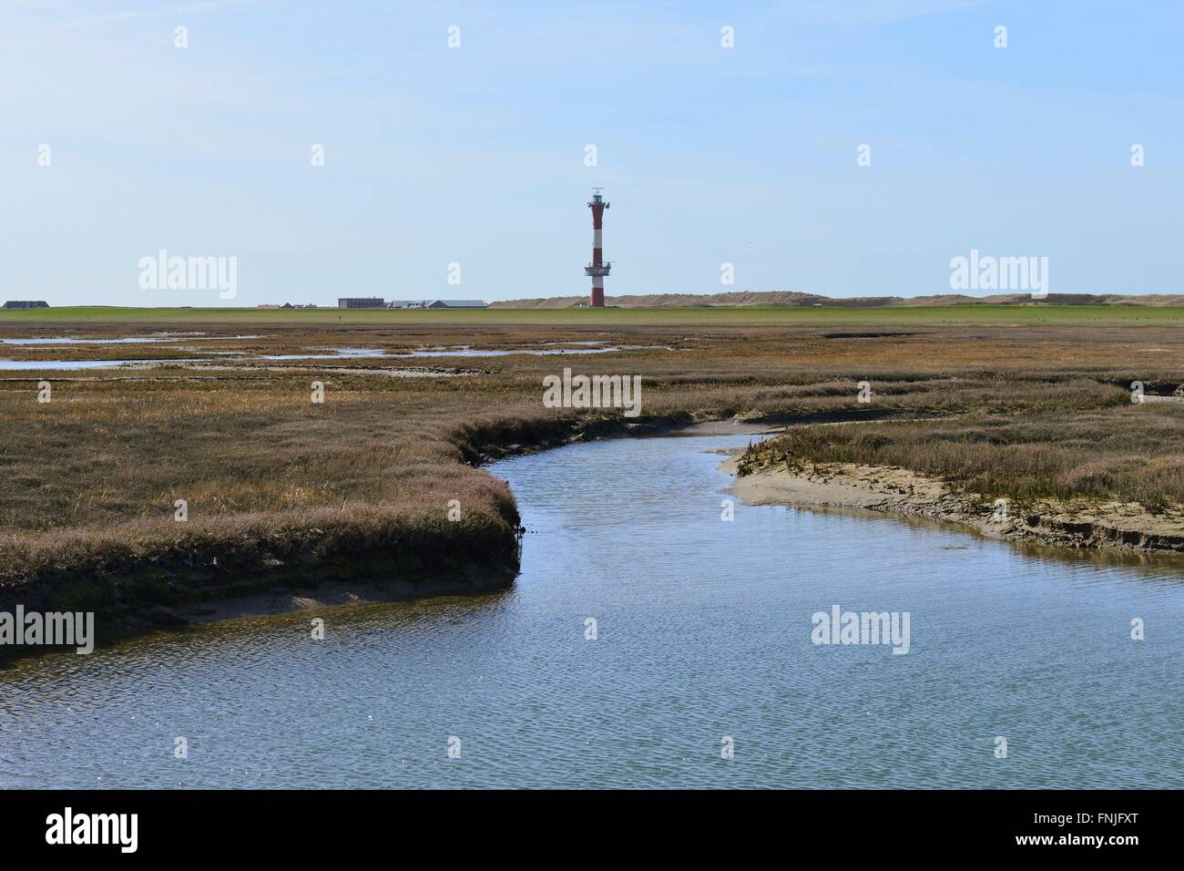Wangerooges lagoon in the west with a wide tideway and the slim lighthouse on the horizon, 20 April 2015 Stock Photo